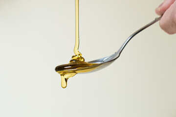 Pouring honey on a spoon