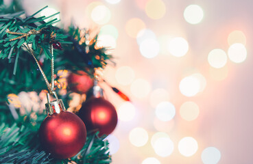 Christmas decoration. Red balls hanging on pine branches Christmas tree garland and ornaments over abstract bokeh background with copy space
