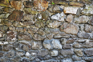 Background, texture, fragment of an old wall, stone of different sizes, on cement