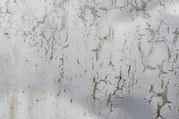 Old corroded metal wall background with scaly gray paint.