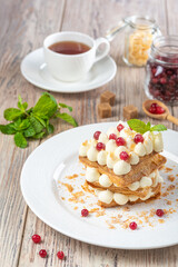 plate with berry dessert and  cup of tea on wooden background, close view 