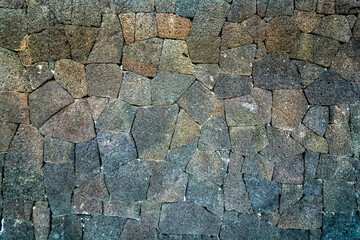 Wall of volcanic stones with grunge texture. Rock background lava abstract wallpaper.