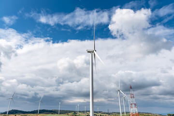 Landscape images of Many wind turbines for generating electricity, located on a wide open ground. And  on high ground, with blue sky and white clouds background, to Power generation concept.