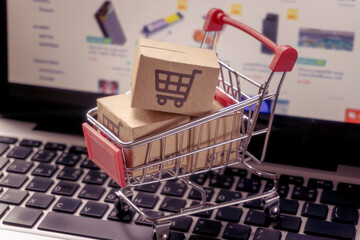 Shopping online concept - Parcel or Paper cartons with a shopping cart logo in a trolley on a...