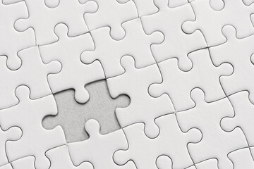 White jigsaw puzzle pattern background. placing last piece of jigsaw puzzle.