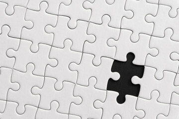 White jigsaw puzzle pattern background. placing last piece of jigsaw puzzle.