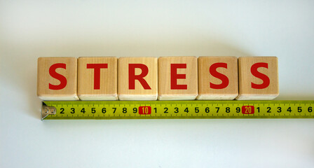 'Stress' word on cubes arranged behind the ruler on beautiful white background. Medical and...