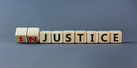 Justice instead of injustice. Turned cubes and changed the word 'injustice' to 'justice' on wooden cubes. Beautiful grey background, copy space. Business concept.