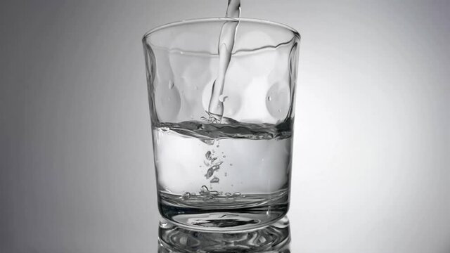 Slow motion of water pouring into glass