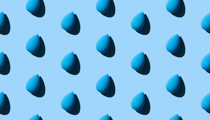 Seamless pattern with cosmetic sponge on blue background