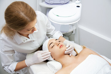 Woman getting ultrasound face beauty treatment in medical spa center.