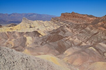 Fototapeta na wymiar Death Valley in California, view from Zabriskie Point, multicolored rock layers, blue sky background