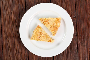 Piece of Spanish omelette on plate. Directly Above.