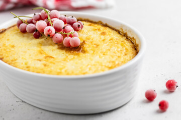 Cheesy rice bake decorated with frozen berries. Space for text.