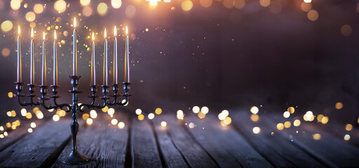 Hanukkah Abstract Defocused Background - Menorah With Bright Dust On Wooden Table - obrazy, fototapety, plakaty