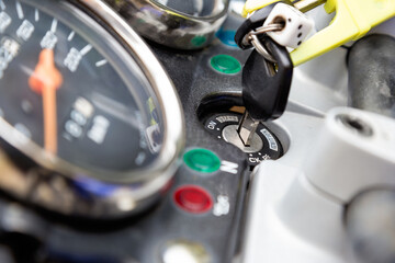 Close up of ignition switch with key and speedometer on motorcycle