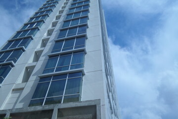 Edge of modern apartment tower with glassy design and cloudy sky
