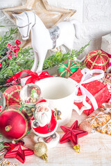 Christmas greeting cad background with decor, baubles, Xmas Gift Boxes, snow globe, hot chocolate cup. White wooden Cozy Festive Winter Christmas Background. Xmas or New Year Composition.