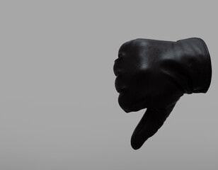 black leather glove showing thumb down gesture. isolated neutral background. copy space