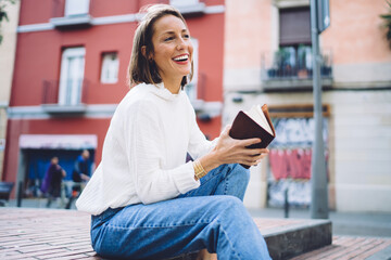 Positive lady with notebook on stairs in park