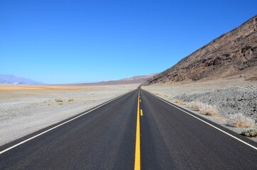 Highway 190 near Badwater Basin in Death Valley, California, blue sky background