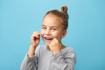 Dental flush, caucasian child girl using flossing teeth and smiling