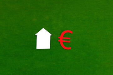The house is white, the Euro sign is red on a green background. Real estate, purchase, sale of residential premises.