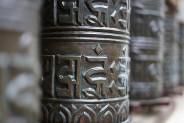 Traditional Tibetan prayer spinning wheels with symbols detail, Buddhism in Asia