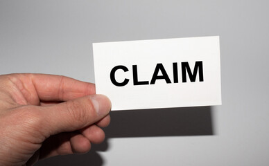 Message on the card CLAIM, in hands of businessman.