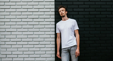 Young bearded hipster guy wearing white blank t-shirt. Mock-up for print. T-shirt template.