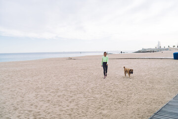 Woman walking with dog along seashore