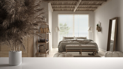 White table top or shelf with straws, dry plants, ornament, ears, sheaf, branch in vase, over cosy wooden peaceful bedroom with double bed and wardrobe, modern minimal interior design