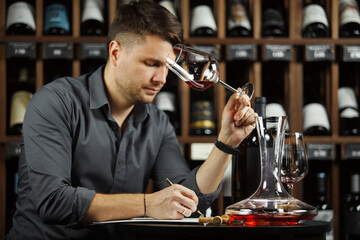 Sommelier degustating red wine poured in glass