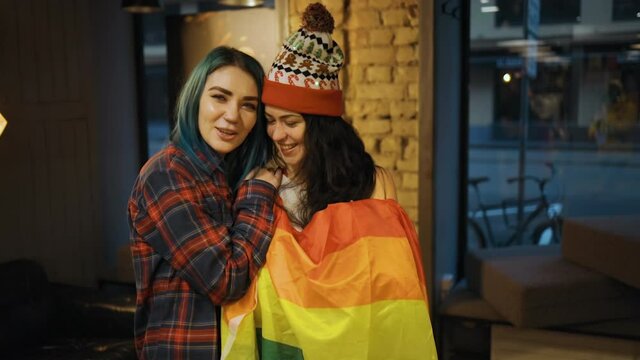 Two cute bisexual women hugging in public indoors
