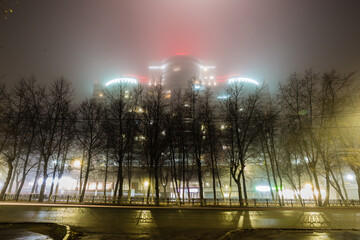 beautifully illuminated building mysteriously emerges through the fog