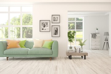 White living room with sofa and summer landscape in window. Scandinavian interior design. 3D illustration