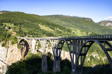 Fototapeta premium Djurdzhevich Bridge over the Tara River canyon. Picturesque mountain landscape of Durmitor National Park, Montenegro, Europe, Balkans, Dinaric Alps, UNESCO World Heritage Site