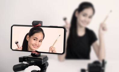 Asian teen woman sit in front of camera and live broadcasting as a beauty blogger influencer or...