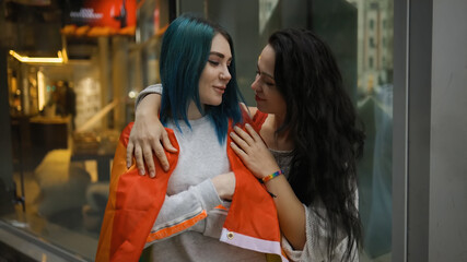 Bisexual woman covers her girlfriend with LGBT rainbow flag