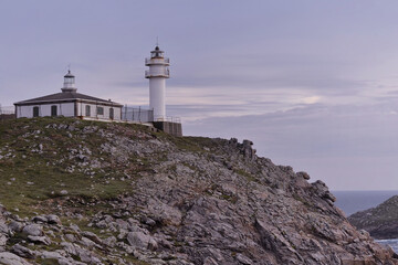 Fototapeta na wymiar Touriñan Lighthouse in Muxia, Galician coast, Spain. Twice a year, at the beginning of spring and the end of summer, Cape Touriñan becomes the last shadow for the sunset in continental Europe.