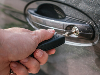 Detail of a woman's hand opening a car door with the key