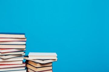 stacks of books for education in the college library on a blue background place for inscription