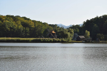 Landscape with lake, forest and windmills in the background