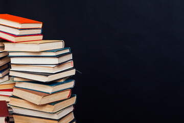 stacks of books for education in the library on a black background place for inscription