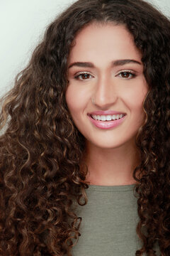 chica etnica de cabello largo sonriendo a c&aacute;mara 