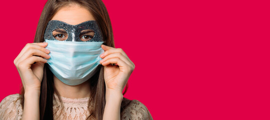 Banner. Girl in a carnival and medical mask, on red background with blank space.