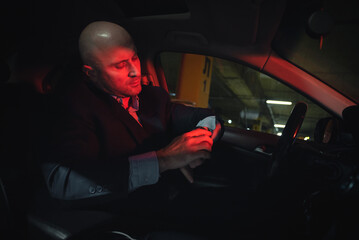 Driver in a suit is looking at his wrist watch.