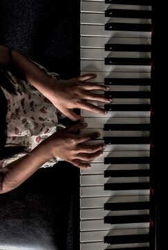 Midsection Of Girl Playing Grand Piano