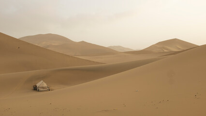 Fototapeta na wymiar sand dunes in the desert with human settlement