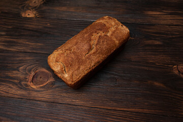 Loaf of homemade bread in a brick background on a wooden background